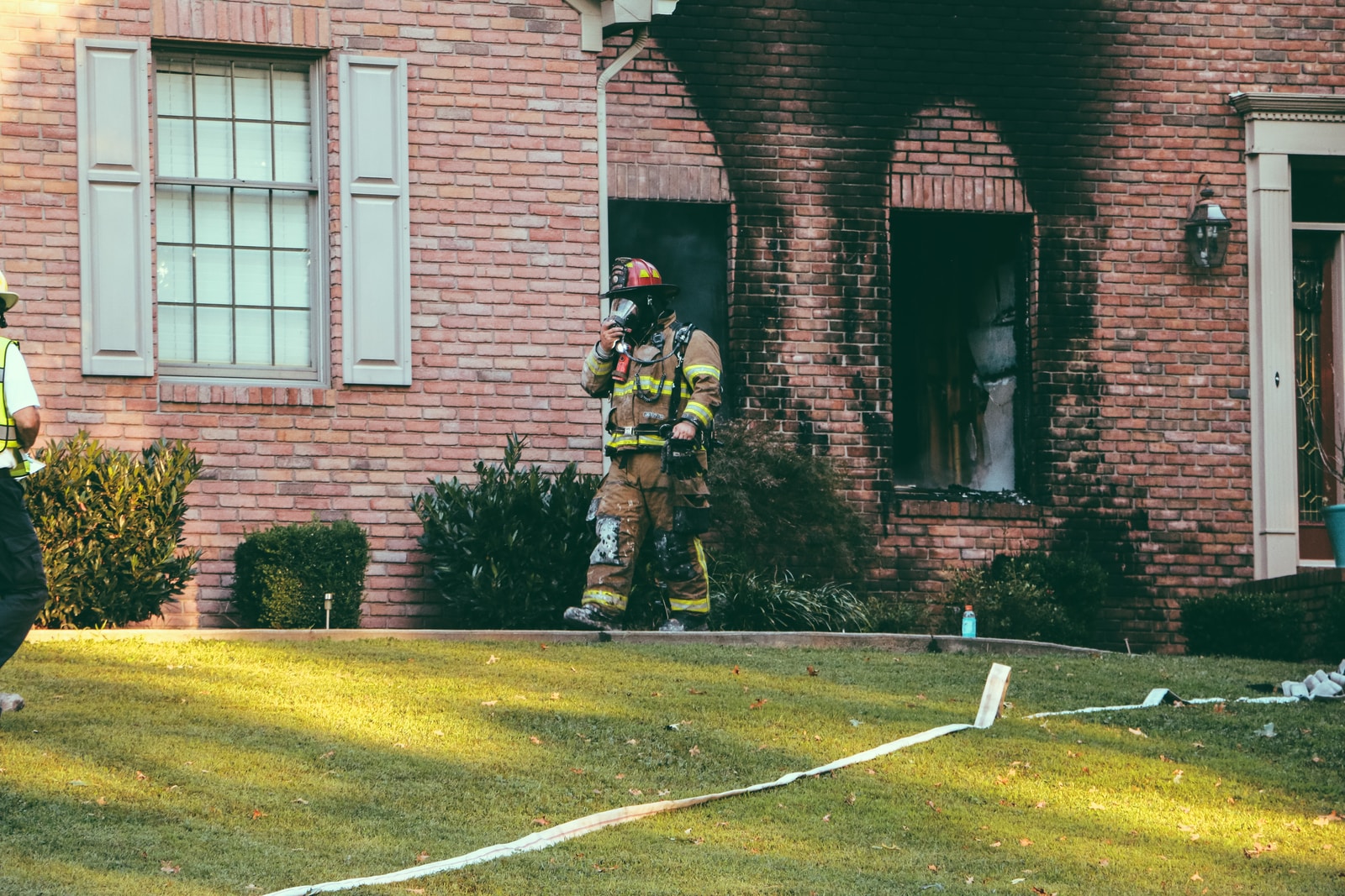 fireman walking in front of brown brick house